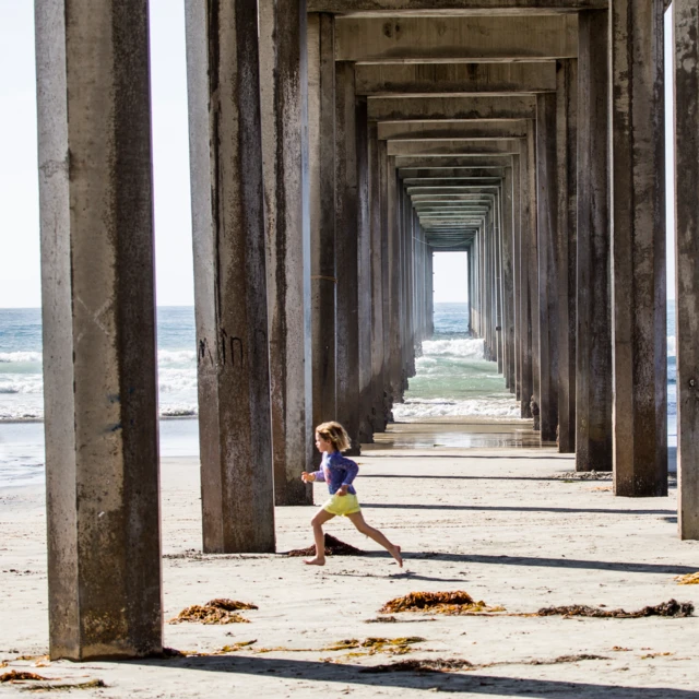 Boy running barefoot on beach