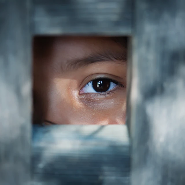 Girl looking through hole