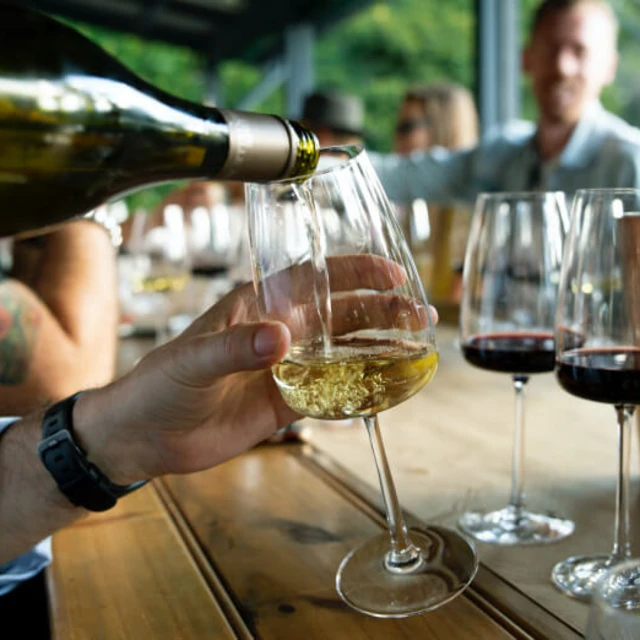 Person pouring a glass of organic white wine