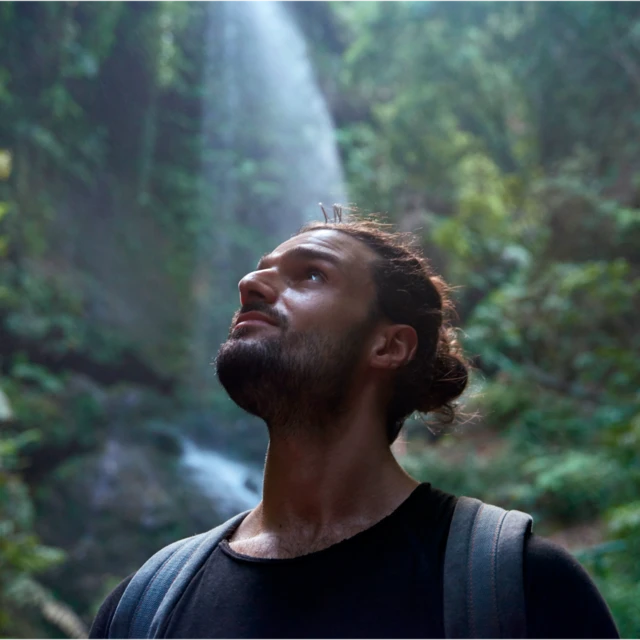 man in jungle looking up