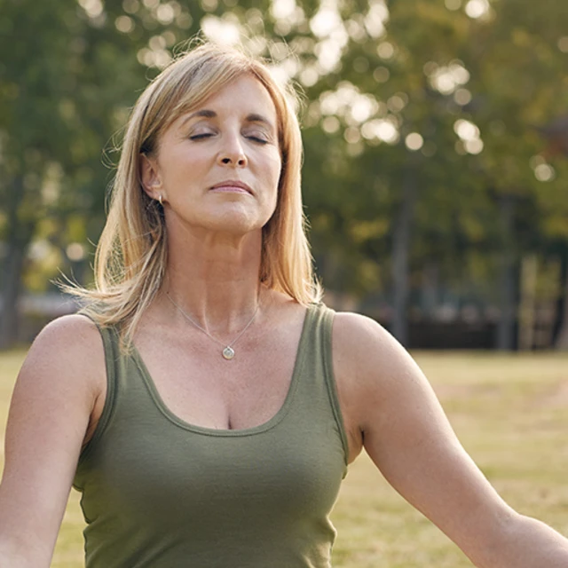 Woman doing yoga on a lawn