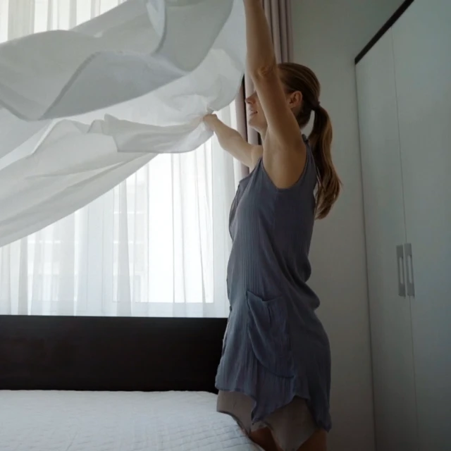 Woman putting a freshly washed oder free linen on her bed