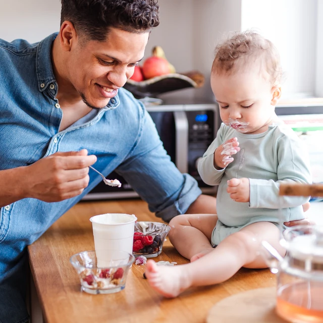 father and child eating yogurt