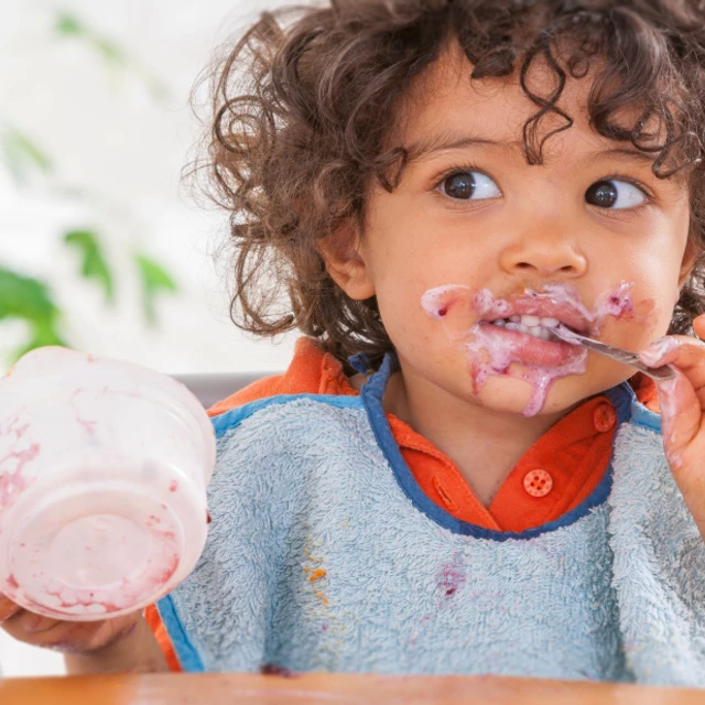 toddler enjoying yogurt so much he got it all over his face