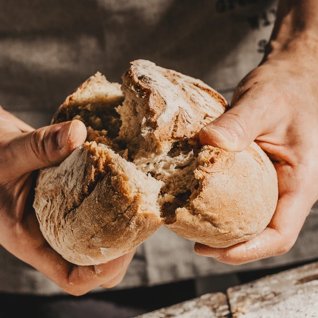 Baker holding fresh bread