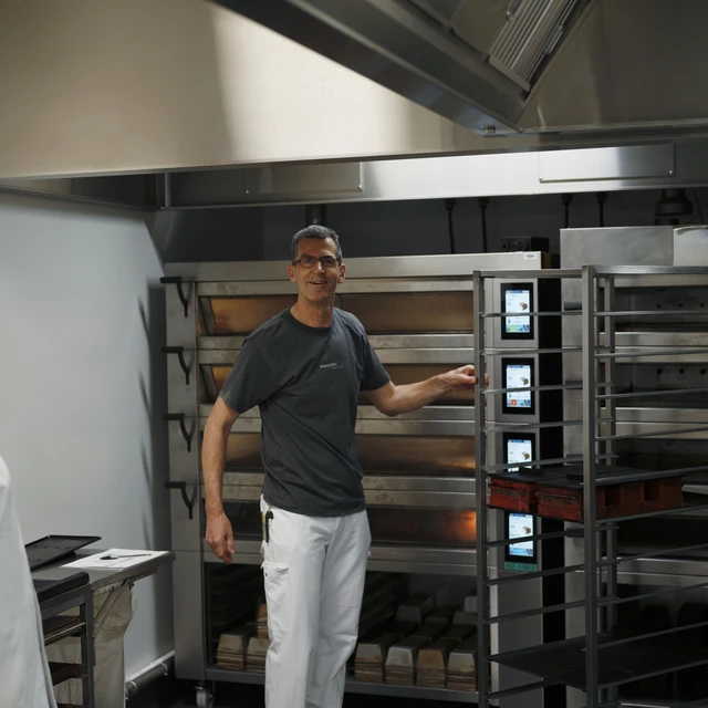 baker standing beside Industrial oven