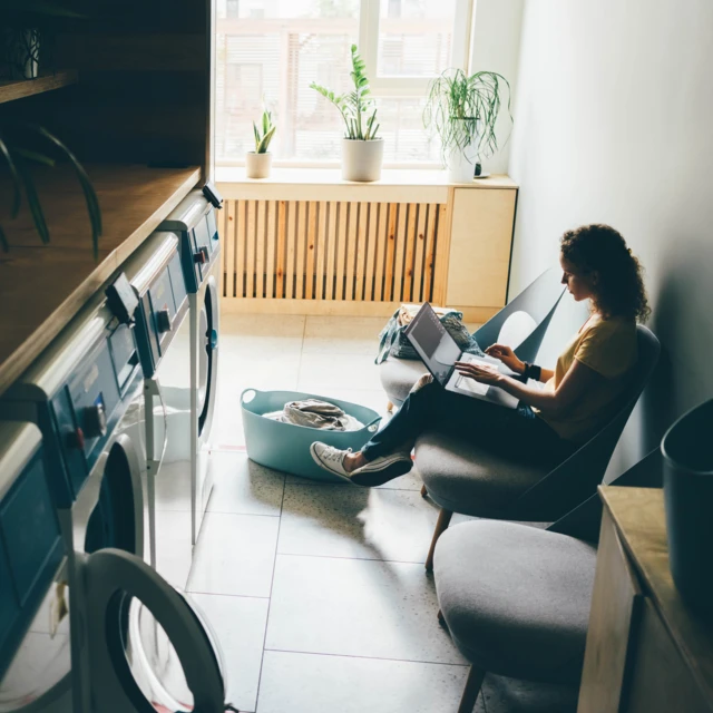 Woman checking computer while waiting for laundry