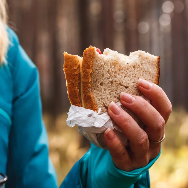 Woman in forest eating pulse sandwich