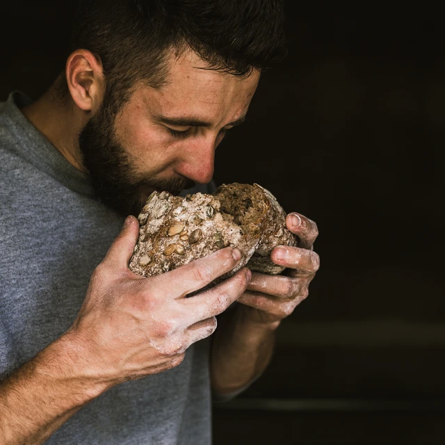 man using his senses to enjoy freshly baked bread