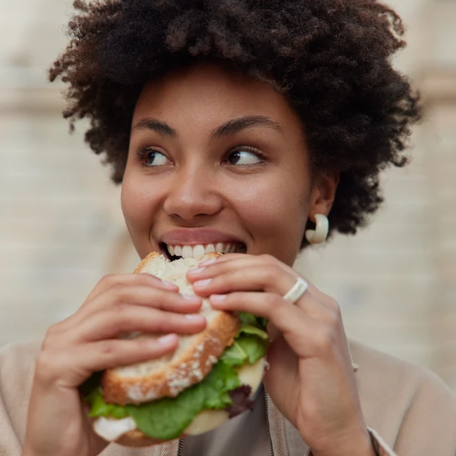 Woman enjoying the first bite of her sandwich