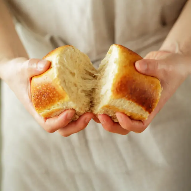 Consumer holding fresh bread with enzymes that ensure softness, elasticity, moistness and a resilient bite
