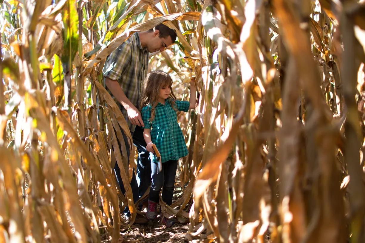 Farmer and daughter in crop field