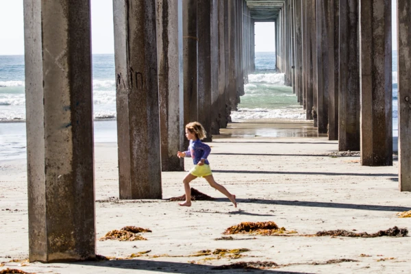 Boy running barefoot on beach