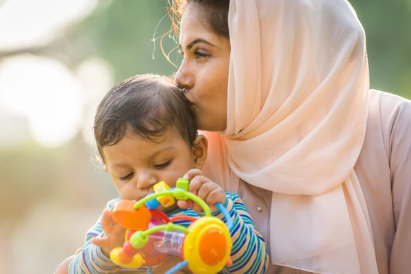 women kissing a infant