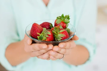Woman holding strawberries in a glass bowl