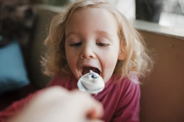 Little girl eating yoghurt
