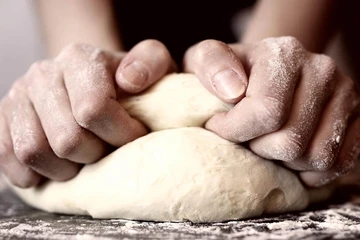 baker kneeding dough