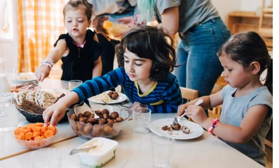 Three kids eating lunch at a table